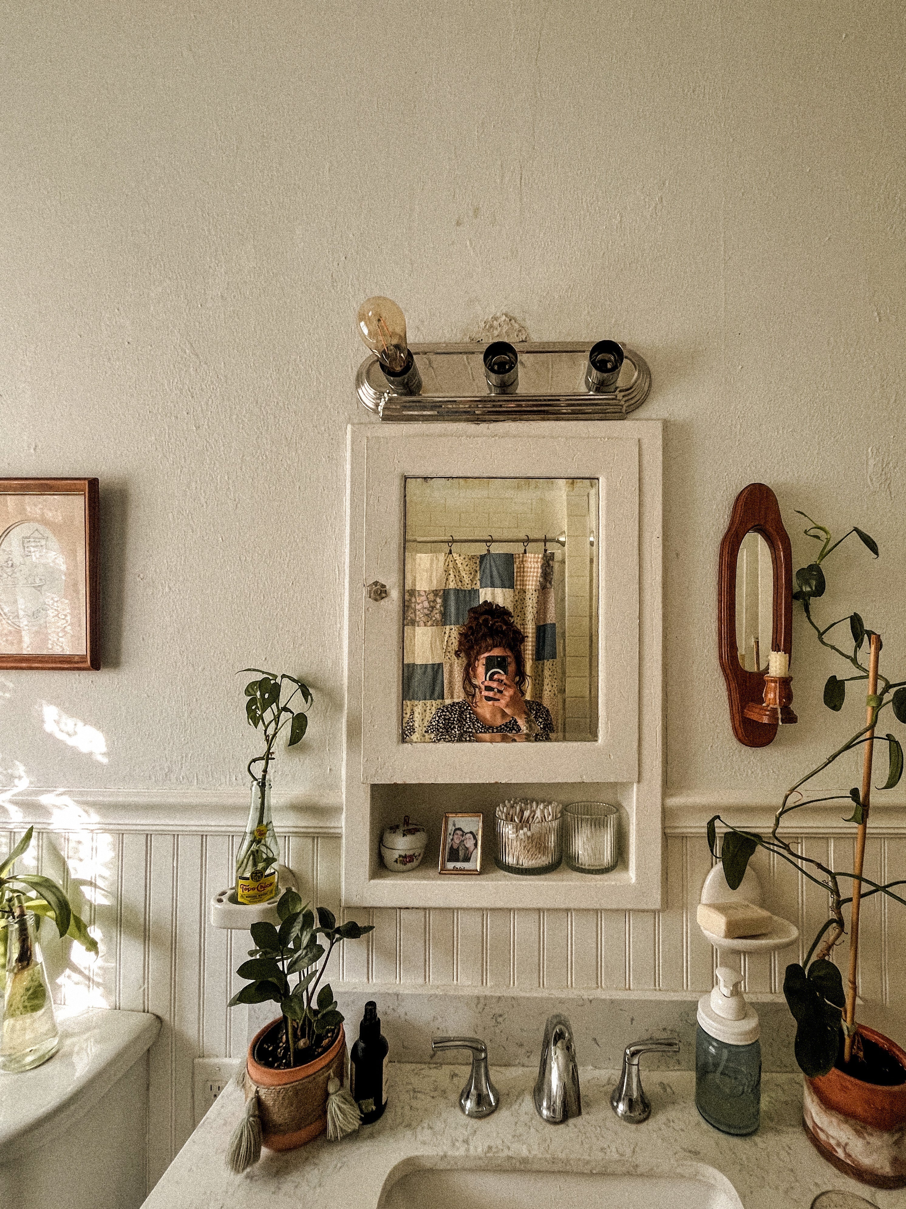 Woman taking a selfie in front of the mirror in a bathroom