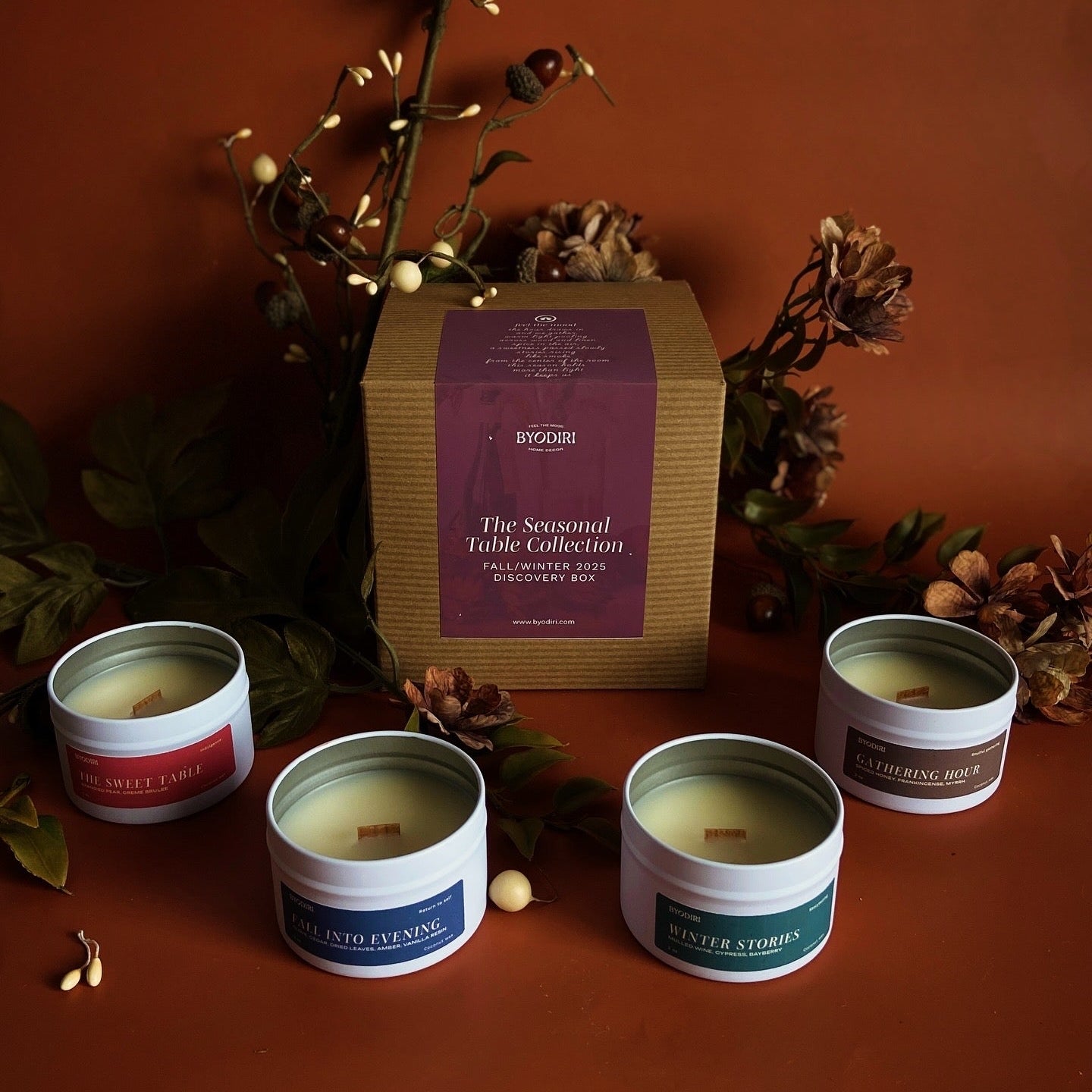 Collection of candles with decorative packaging on a warm brown background